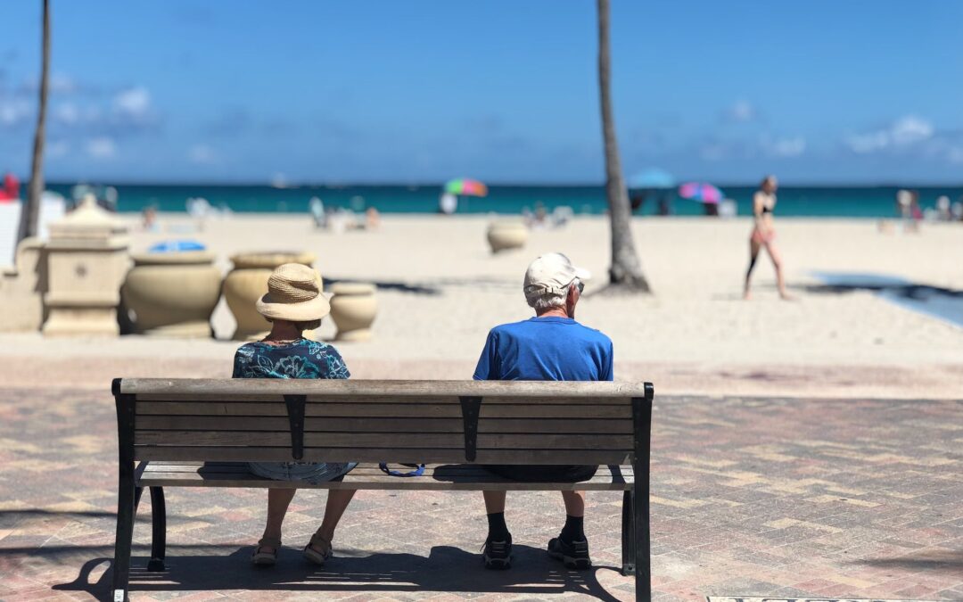 retirement challenged couple on bench at the beach